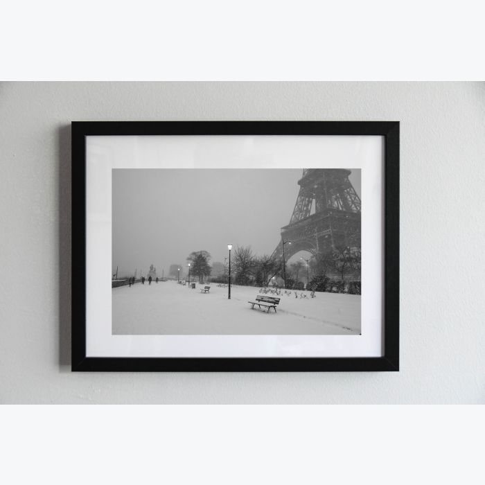 Photo, en noir et blanc,  de la tour Eiffel sous la neige